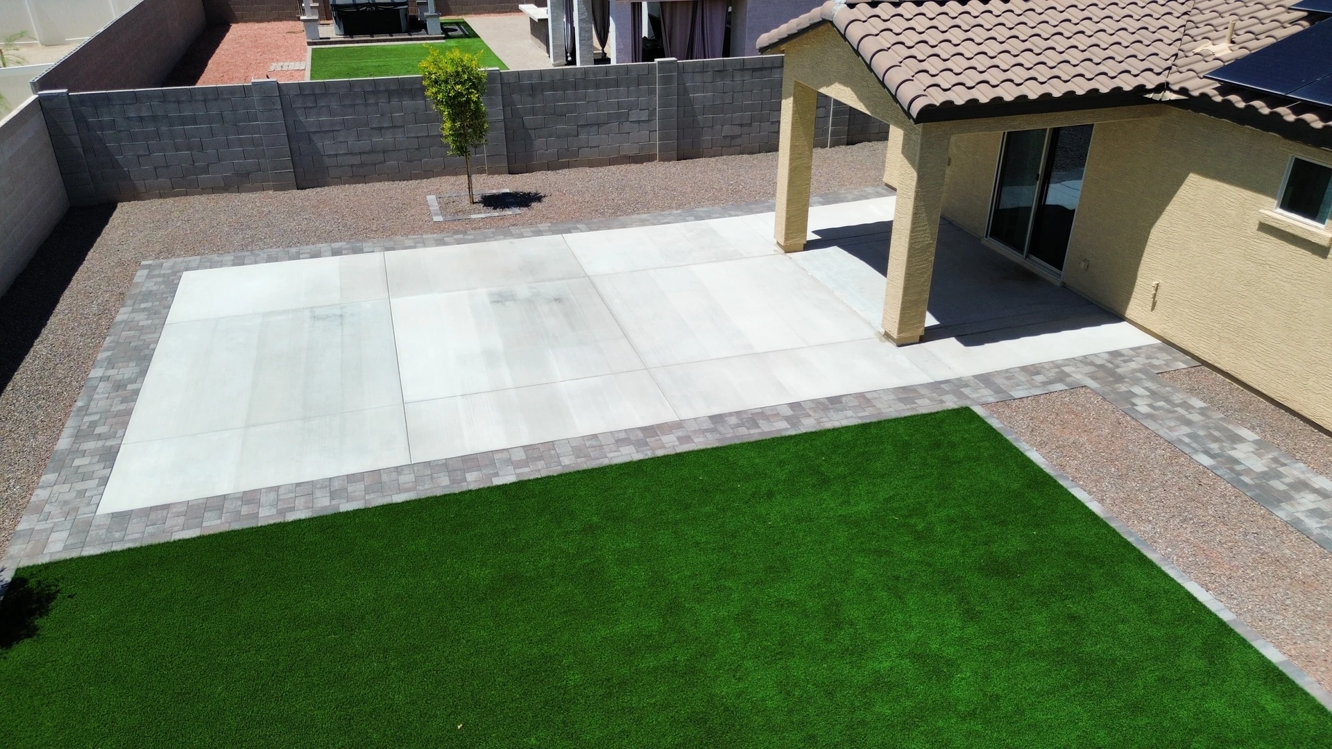 Aerial view of new concrete patio slab with paver border, turf, and gravel yard, AZ Elevate concrete and grading Phoenix