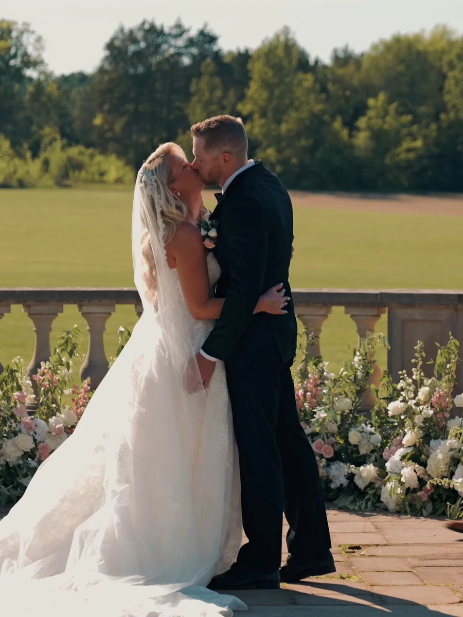 A couple's first kiss at their outdoor ceremony